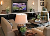 Thumbnail 41 of 117 - A living room with a flat screen TV mounted above a coffee table.