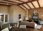 Thumbnail 46 of 117 - A living room with a couch, chairs, and a television.
