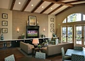 Thumbnail 48 of 117 - A living room with a couch, chairs, and a television.