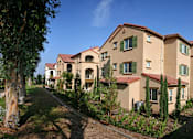 Thumbnail 14 of 117 - A row of houses with green trees in front.