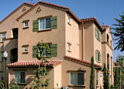Thumbnail 10 of 117 - A building with a red tile roof and green shutters.