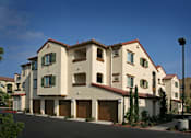 Thumbnail 8 of 117 - A row of houses with garages and green shutters.