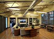 Thumbnail 8 of 45 - A modern office lobby with a reception desk and seating area.