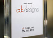 Thumbnail 21 of 45 - A framed sign with the letters CDC on it, with the website and phone number for CDC Designs underneath.