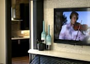 Thumbnail 22 of 45 - A modern living room with a television displaying a man playing a violin.