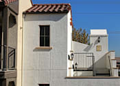 Thumbnail 27 of 45 - A white house with a red tile roof and a black metal railing.