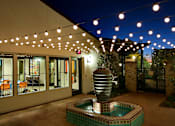 Thumbnail 36 of 45 - A patio with a pool and lights strung above it.