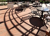 Thumbnail 43 of 45 - A patio with tables and chairs under a metal awning.