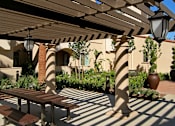 Thumbnail 45 of 45 - A patio with a bench and a lamp post under a wooden pergola.