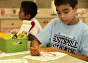 Thumbnail 39 of 126 - A boy in a Southpole Authentic t-shirt is writing at a table.