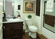 Thumbnail 34 of 126 - A bathroom with a toilet, sink, and a painting on the wall.