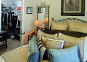 Thumbnail 27 of 126 - A bedroom with a bed, a mirror, and a lamp.
