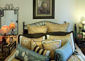 Thumbnail 25 of 126 - A bed with a striped pillow and a floral pillow is in the foreground.