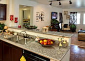Thumbnail 49 of 126 - A kitchen with a granite countertop and a bowl of fruit on it.