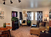 Thumbnail 18 of 126 - A living room with a brown couch, a wooden table, and a fireplace.