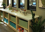 Thumbnail 13 of 126 - A reception desk with a white counter and a green plant on it.