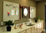 Thumbnail 23 of 126 - A kitchen with a white counter top and wooden cabinets.