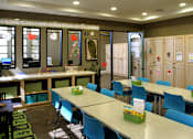 Thumbnail 17 of 126 - A room with tables and chairs and a wall with drawings on it.