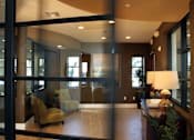 Thumbnail 29 of 126 - A modern living room with a glass door and a yellow armchair.