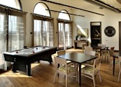 Thumbnail 117 of 126 - A pool table is in the middle of a room with a dining table and chairs.