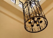 Thumbnail 111 of 126 - A chandelier hangs from a ceiling with a wooden beam and three windows.