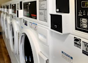Thumbnail 45 of 126 - A row of white washing machines in a public laundromat.