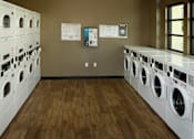 Thumbnail 119 of 126 - A laundromat with rows of washers and dryers.