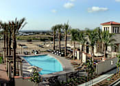 Thumbnail 105 of 126 - A view of a resort with a pool and palm trees.