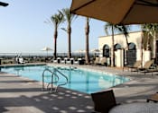 Thumbnail 98 of 126 - A pool surrounded by palm trees and lounge chairs.