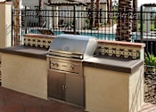 Thumbnail 90 of 126 - A built in stainless steel grill is on a tan wall.