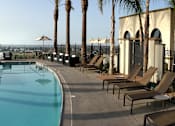 Thumbnail 103 of 126 - A large swimming pool surrounded by sun loungers and palm trees.