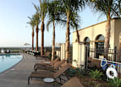 Thumbnail 70 of 126 - A pool surrounded by palm trees and lounge chairs.