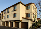Thumbnail 66 of 126 - A two-story building with a beige facade and brown garage doors.
