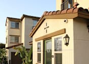 Thumbnail 53 of 126 - A small house with a brown door and a cross on the front.