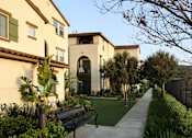 Thumbnail 56 of 126 - A bench is on a sidewalk in front of a building.