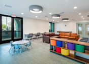 Thumbnail 16 of 16 - A conference room with a white table and chairs, a couch, and a TV.