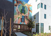 Thumbnail 2 of 16 - A modern building with a mural on the side.