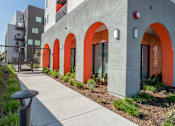 Thumbnail 12 of 16 - A modern building with orange arches and a concrete facade.