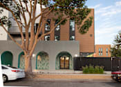 Thumbnail 3 of 16 - A modern building with a tree in front of it.