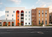 Thumbnail 9 of 16 - A modern building with a white facade and orange accents.