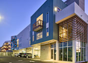 Thumbnail 8 of 11 - A modern building with a blue and white exterior and a wooden slatted wall.
