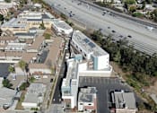 Thumbnail 9 of 11 - A highway runs through a city with buildings on either side.