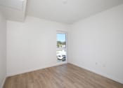 Thumbnail 16 of 17 - Empty room with a window and wooden floor.