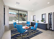Thumbnail 4 of 17 - A modern living room with blue chairs and a black and white rug.