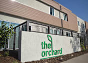 Thumbnail 1 of 10 - The Orchard building has a white sign with green lettering.