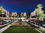 Thumbnail 1 of 102 - A parking lot with cars and a building in the background.