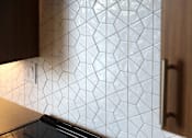 Thumbnail 29 of 102 - A kitchen with a tile backsplash and a wooden cabinet.