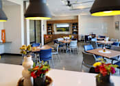 Thumbnail 26 of 102 - A dining area with tables and chairs and a vase of flowers on the table.