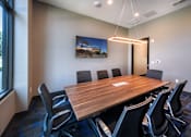 Thumbnail 25 of 102 - A conference room with a long table and chairs.