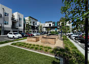 Thumbnail 48 of 102 - A modern apartment complex with a parking lot in front.